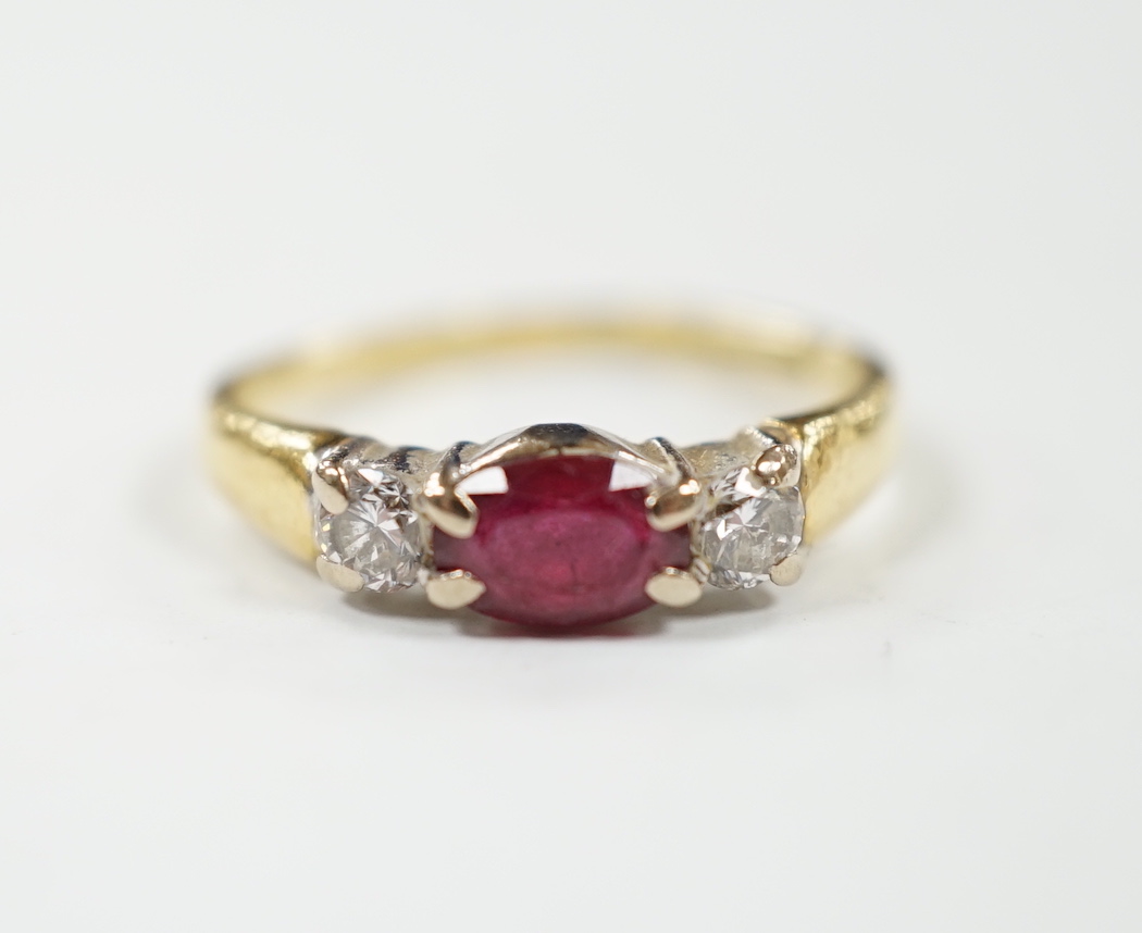 A modern 18ct gold, ruby and diamond set three stone ring, shank misshapen, gross weight 2.9 grams.